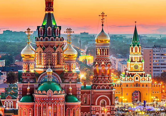 Nice view of the town at sunset. Orthodox church surrounded by beautiful red brick buildings on the city's embankment. Volga region of Russia, the city of Yoshkar-Ola